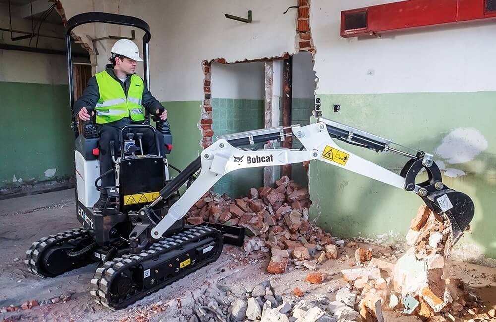 Mini-excavator cu cupa Bobcat E10e in interiorul cladirii